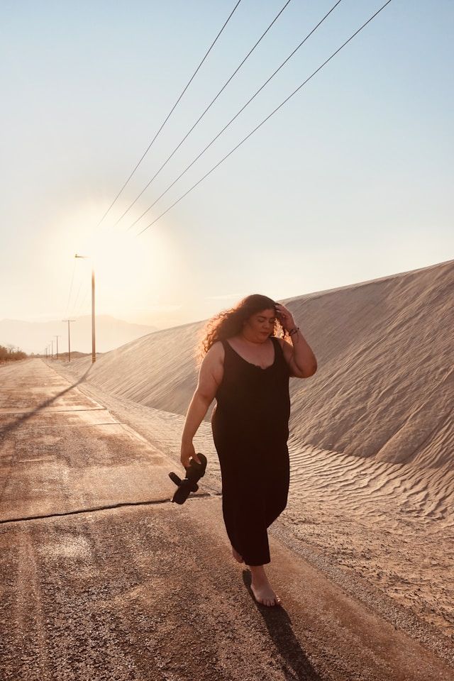 Mujer caminando con el atardecer de fondo