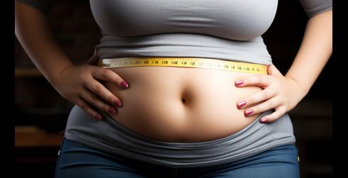 Una mujer midiendo su cintura con una cinta métrica, destacando su sección media y con las manos en las caderas, simbolizando esfuerzos de pérdida de peso o fitness.