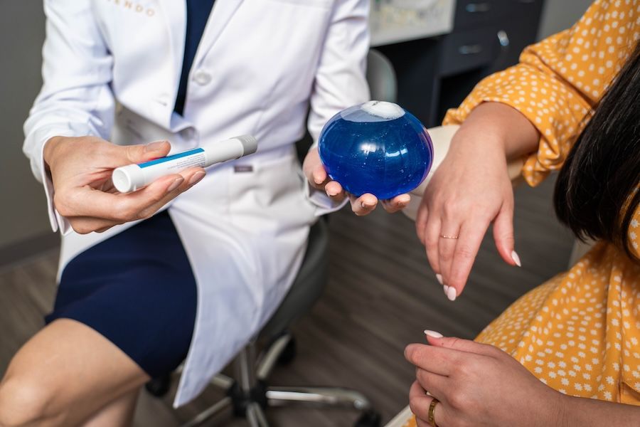 Un médico mostrando el balón gástrico y Wegovy a un paciente.